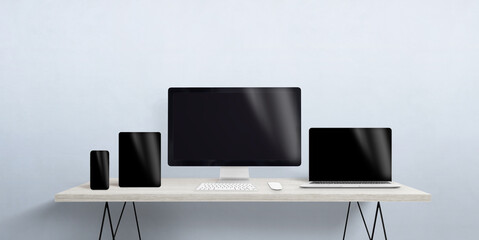 Turned off devices of different sizes on the desktop. Blank screen for responsive web page or app promotion. Computer display, laptop, tablet and smart phone