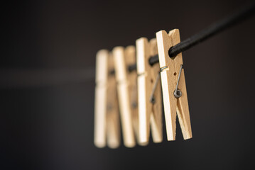 Den Helder, Netherlands. July 2022. Wooden clothes pegs on a black background. Selective focus.