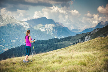 Naklejka na ściany i meble Young woman hiking in the mountains