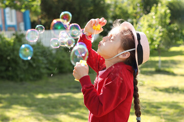 A little girl blowing soap bubbles