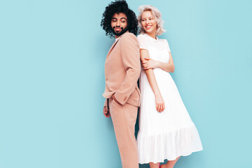 Smiling beautiful woman and her handsome boyfriend. Sexy cheerful multiracial family having tender moments on beige background in studio. Multiethnic models hugging. Embracing each other.Love concept