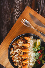 Asian cuisine. Shrimp with curry rice. Appetizing dish on an orange background