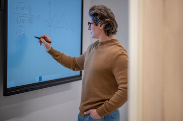 A school teacher writing formulas on the board
