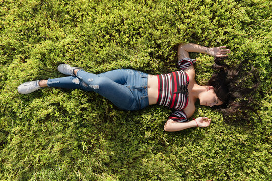 Full Length Of Woman Lying On Grass Field