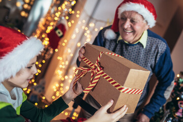 Grandfather and grandson with gifts during Christmas holidays.