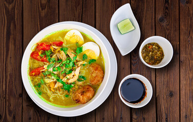 INDONESIAN CULINARY CHICKEN SOUP NOODLE WITH SLICE BOILING EGG AND FRIED MASHED POTATOS AS TOPPING