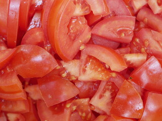 Large red delicious tomatoes sliced for salad. Vitamin food for vegetarians, ready to eat. Ripe fragrant vegetables without spices.