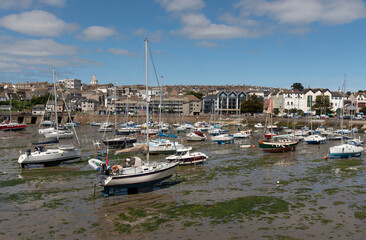 Fototapeta na wymiar Penzance, Cornwall, England, UK. 2022. Penzance Harbour with boats settled on the mud with a backdrop of the town centre. Cornwall UK.