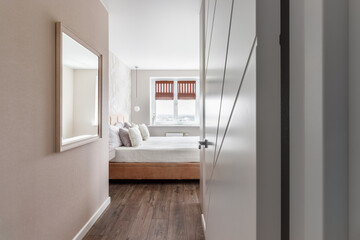 White pillows, duvet and duvet case on a blue bed. White bed linen on a blue sofa. Bedroom with bed and bedding and poster frame mock up on the wall