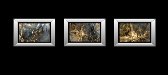 3 silver frames of abstract photographs of the deserts of Africa from the air, on a black wall background,