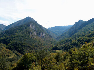 Fototapeta premium Scenic mountain landscape, view of the mountain range with the forest, green trees, and blue sky