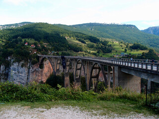 Fototapeta na wymiar View of the old concrete arch bridge in the canyon of a mountain river, Đurđevića Tara Bridge, Tara River Canyon, Montenegro.