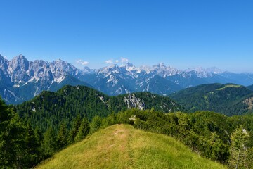 Fototapeta na wymiar View of mountain peaks in Julian alps and Triglav national park, Slovenia and a ridge in Karavanke mountains bellow Trupijevo Poldne