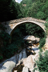 Fototapeta na wymiar Aosta Valley, Italy - The ancient Roman bridge over the river in the little village named ( Pontboset).
