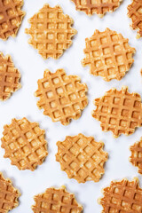 Vertical background of appetizing sweet waffles on a white background. Summer, bright, trendy background, food design