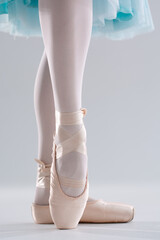 Ballerina in pointe shoes. Ballet posing, performance. Woman's legs with shoes for ballet dancing on white background © Dmitriy