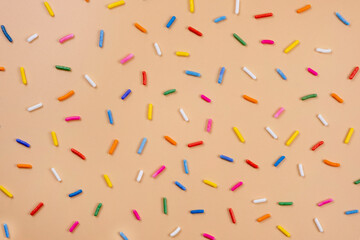 Fototapeta na wymiar background of sprinkles for sweets on a beige background.The concept of celebrating a birthday, party or other holidays.fashionable,sweet background