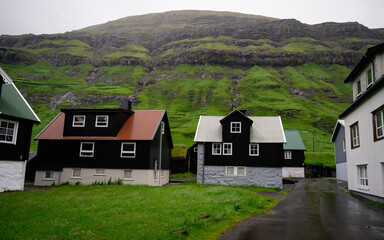 Fototapeta na wymiar Beautiful view of the Tjornuvik village in the middle of the Mountains in Faroe Island