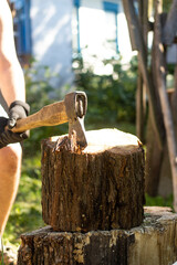 Man is chopping wood with an ax in the countryside. Detail of two flying pieces of wood on a log with sawdust. A man is chopping wood with an old axe. Frozen moment.