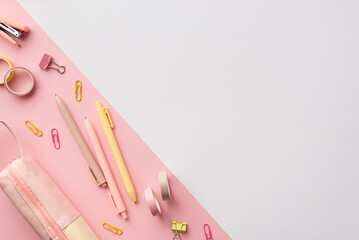 School accessories concept. Top view photo of pink and yellow stationery pens mini stapler binder clips adhesive tape and pencil-case on bicolor pink and white background with copyspace