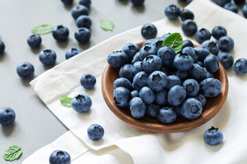 Naklejka na ściany i meble Bowl or plate blueberries blueberry with leaves on kitchen table