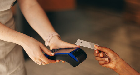 Unrecognizable customer paying her bill using a credit card