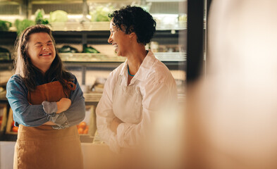 Grocery store workers laughing happily in their shop