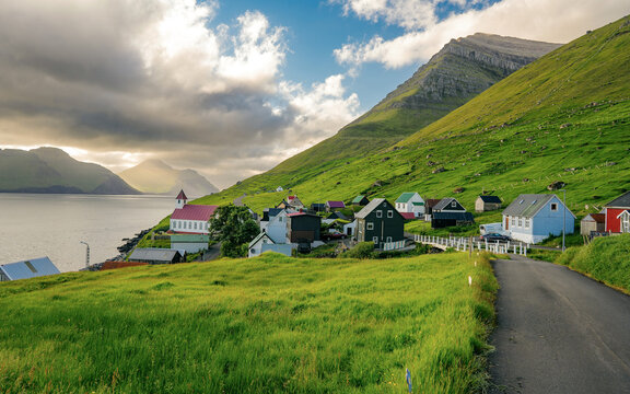 Traditional Faroe village of Kunoy with picturesque church and mountain