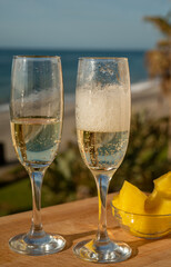 Outdoor breakfast with Spanish cava sparkling wine and pineapple with view on blue sea and sandy beach in Marbella, Costa del Sol vacation destination, Andalusia, Spain