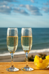 Outdoor breakfast with Spanish cava sparkling wine and pineapple with view on blue sea and sandy beach in Marbella, Costa del Sol vacation destination, Andalusia, Spain