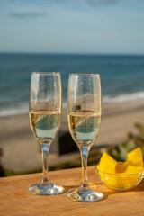Outdoor breakfast with Spanish cava sparkling wine and pineapple with view on blue sea and sandy beach in Marbella, Costa del Sol vacation destination, Andalusia, Spain