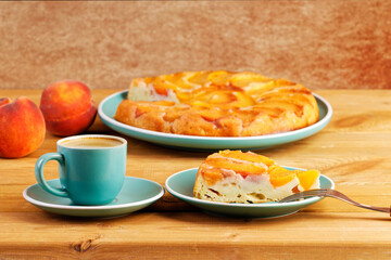 Homemade pie with peaches and cup of coffee espresso on wooden table. Shallow focus.