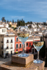 Two glasses of Spanish dry rueda white wine served on roof terrace with view on old part of Andalusian town Granada, Spain