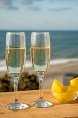 Outdoor breakfast with Spanish cava sparkling wine and pineapple with view on blue sea and sandy beach in Marbella, Costa del Sol vacation destination, Andalusia, Spain