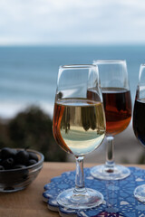 Tasting of Spanish sweet and dry fortified Vino de Jerez sherry wine and green olives with view on blue sea near El Puerto de Santa Maria, Andalusia, Spain