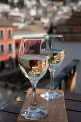 Two glasses of Spanish dry rueda white wine served on roof terrace with view on old part of Andalusian town Granada, Spain