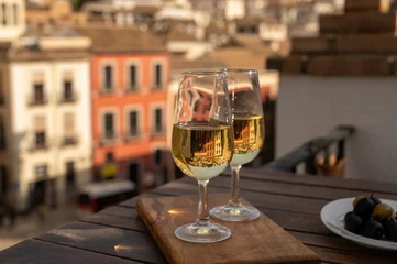 Fotobehang Tasting of Spanish sweet and dry fortified Vino de Jerez sherry wine with view on roofs and houses of old andalusian town © barmalini