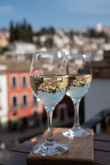 Two glasses of Spanish dry rueda white wine served on roof terrace with view on old part of Andalusian town Granada, Spain