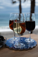 Tasting of Spanish sweet and dry fortified Vino de Jerez sherry wine and green olives with view on blue sea near El Puerto de Santa Maria, Andalusia, Spain