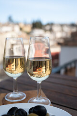 Tasting of Spanish sweet and dry fortified Vino de Jerez sherry wine and olives with view on roofs and houses of old andalusian town