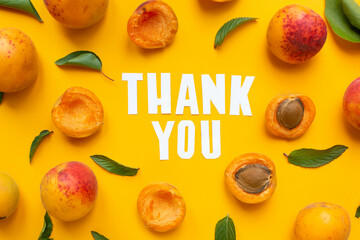  apricots and leaves with paper words. Thank you on orange paper