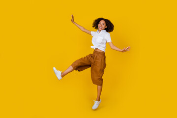 Full body portrait of excited crazy person jumping enjoy free time isolated on yellow color background
