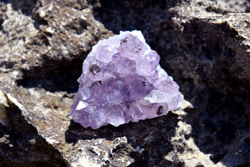 A beautiful amethyst druze lies on a stone. A splice of purple crystals of semi-precious quartz.
