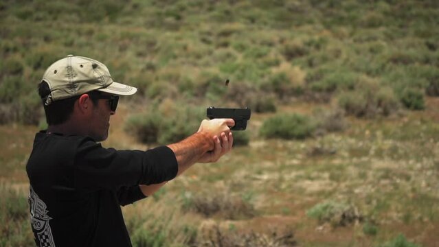 A male gunman with a baseball cap fires a handgun at targets in 120fps slow motion
