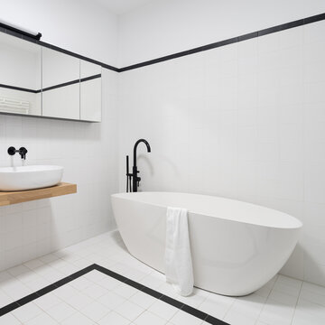 Bathtub with black tap in minimalist bathroom