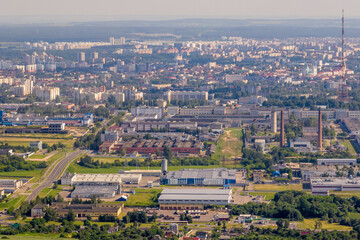 ariel panoramic view of city and skyscrapers with a huge factory with smoking chimneys in the...