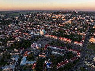 Fototapeta premium ariel panoramic view of city and skyscrapers with a huge factory with smoking chimneys in the background