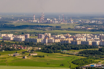ariel panoramic view of city and skyscrapers with a huge factory with smoking chimneys in the background