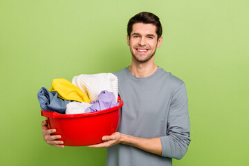 Photo of young brunet guy do laundry wear shirt isolated on green color background - obrazy, fototapety, plakaty