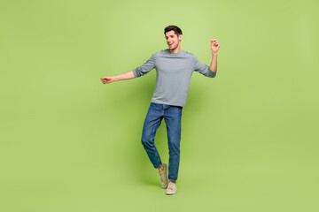 Full size photo of attractive good mood cheerful male enjoy his hobby dancing isolated on green...